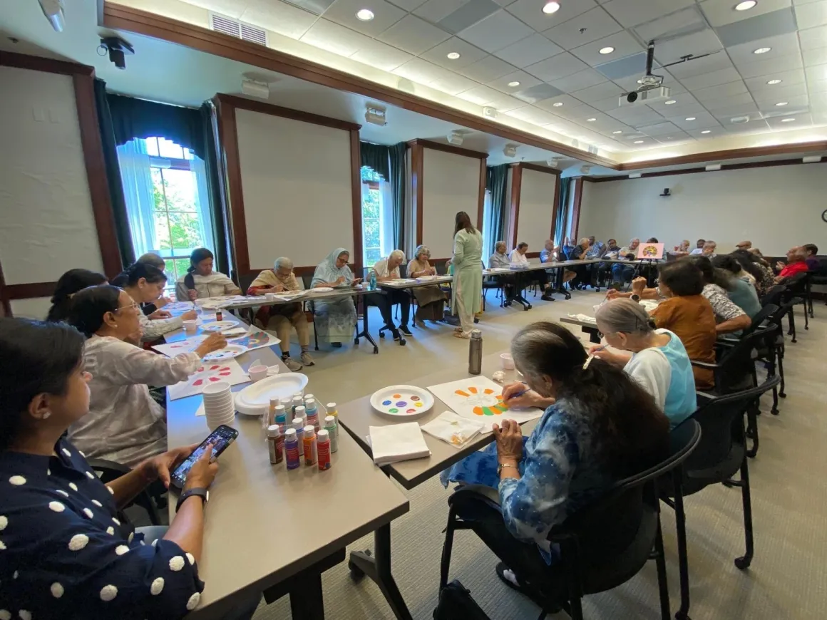 People painting in a classroom setting.