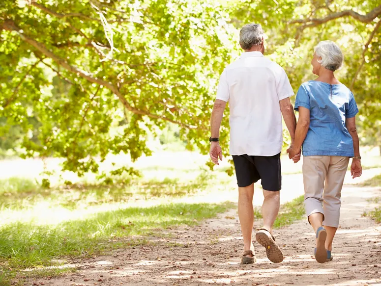 Elderly couple walking in sunny park