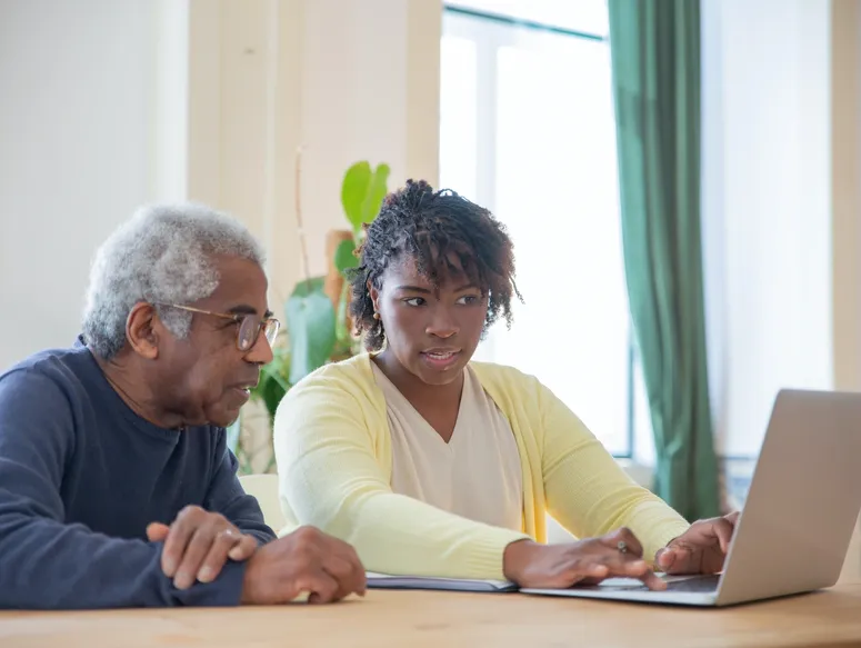 Older man and younger woman using computer