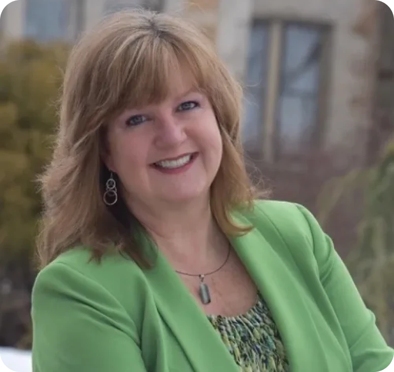 Woman outdoors wearing green and smiling