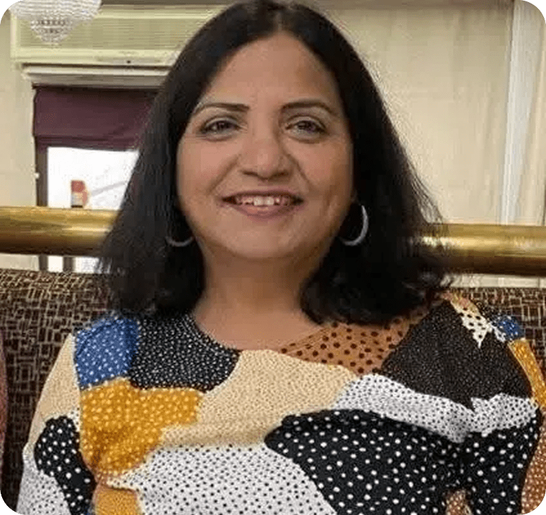Smiling woman in colorful patterned top.
