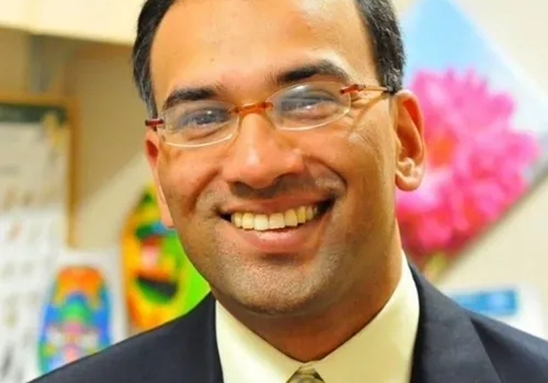 Professional portrait of a smiling man.