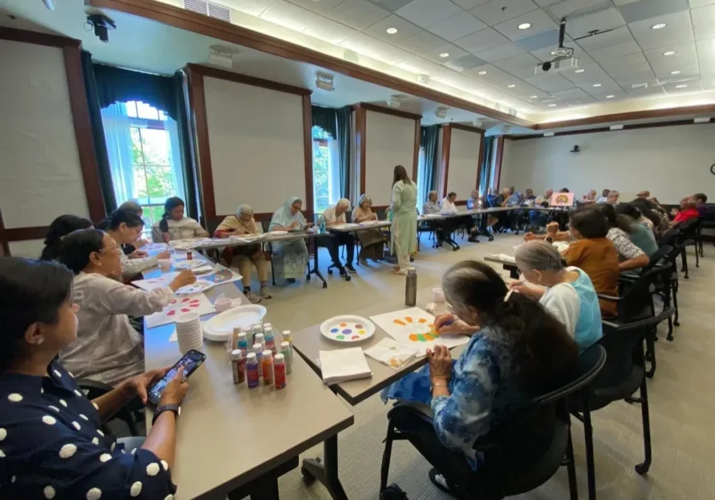 People painting in a classroom setting.