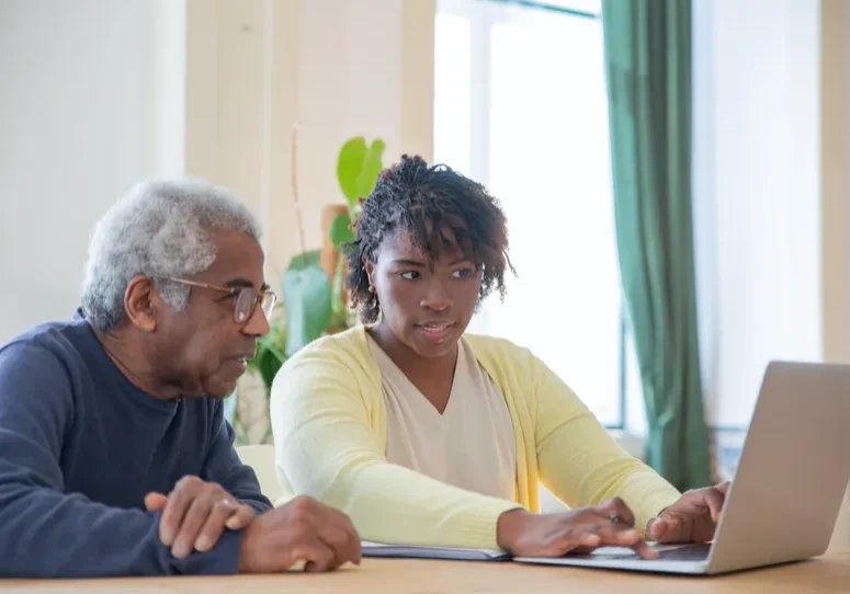 Older man and younger woman using computer